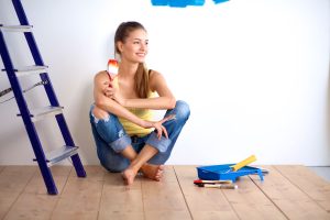 a woman sitting on the floor next to a ladder.