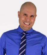 a bald man wearing a blue shirt and tie.